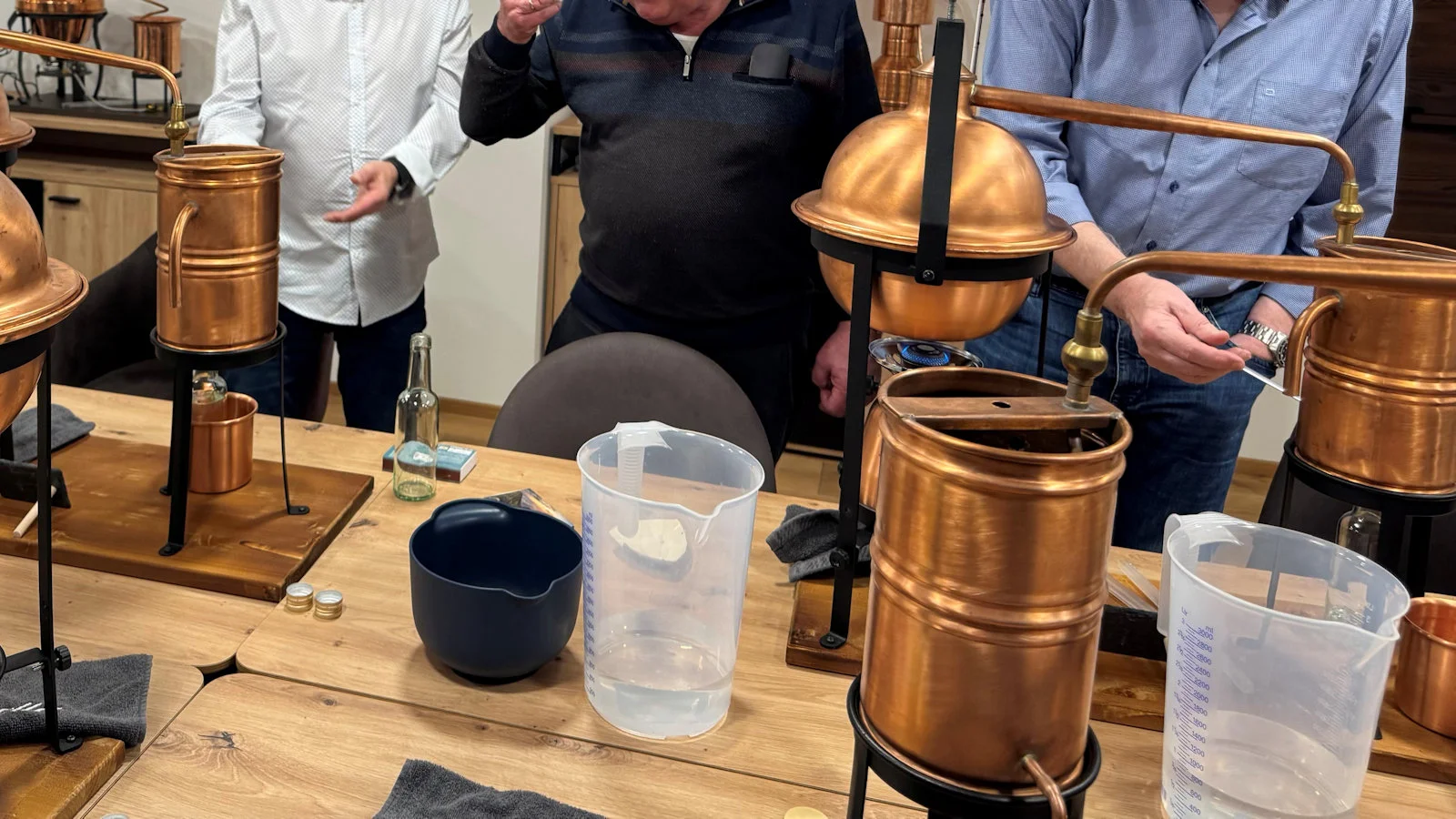 Teilnehmer arbeiten aktiv an der Destille und stellen ihre eigenen ätherischen Öle oder Spirituosen her.